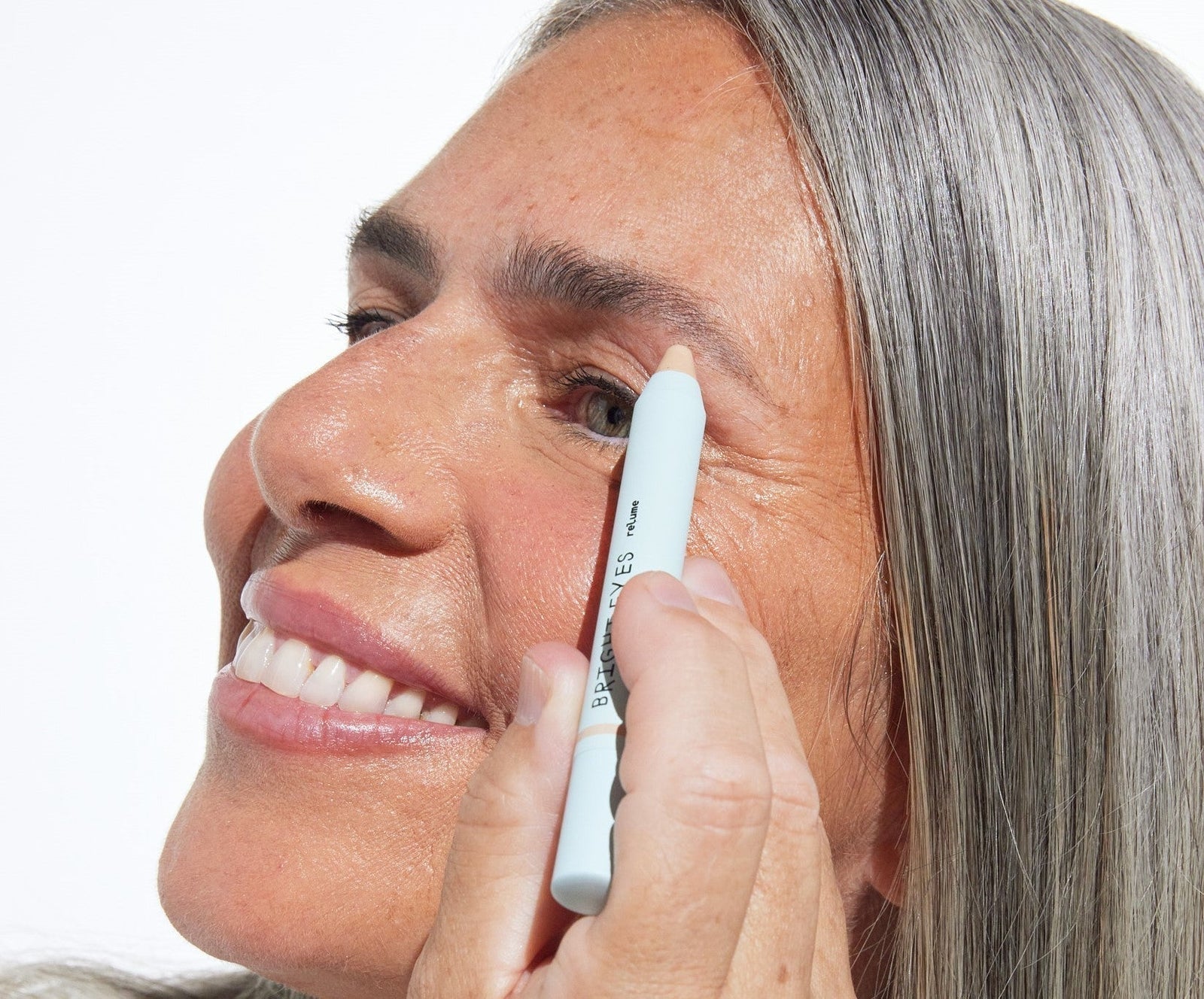 Woman applying Relume Bright Eyes Brow Highlighter under the arch to lift and define her brows.