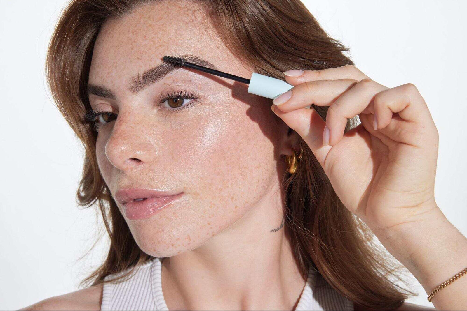 A girl using a product from Relume Cosmetics, designed as the best eyebrow solution for sparse brows.